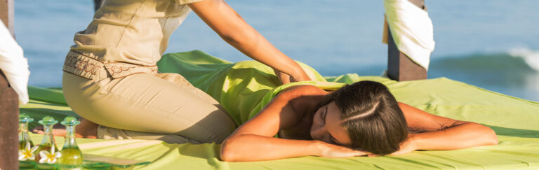A woman enjoys a beach massage.