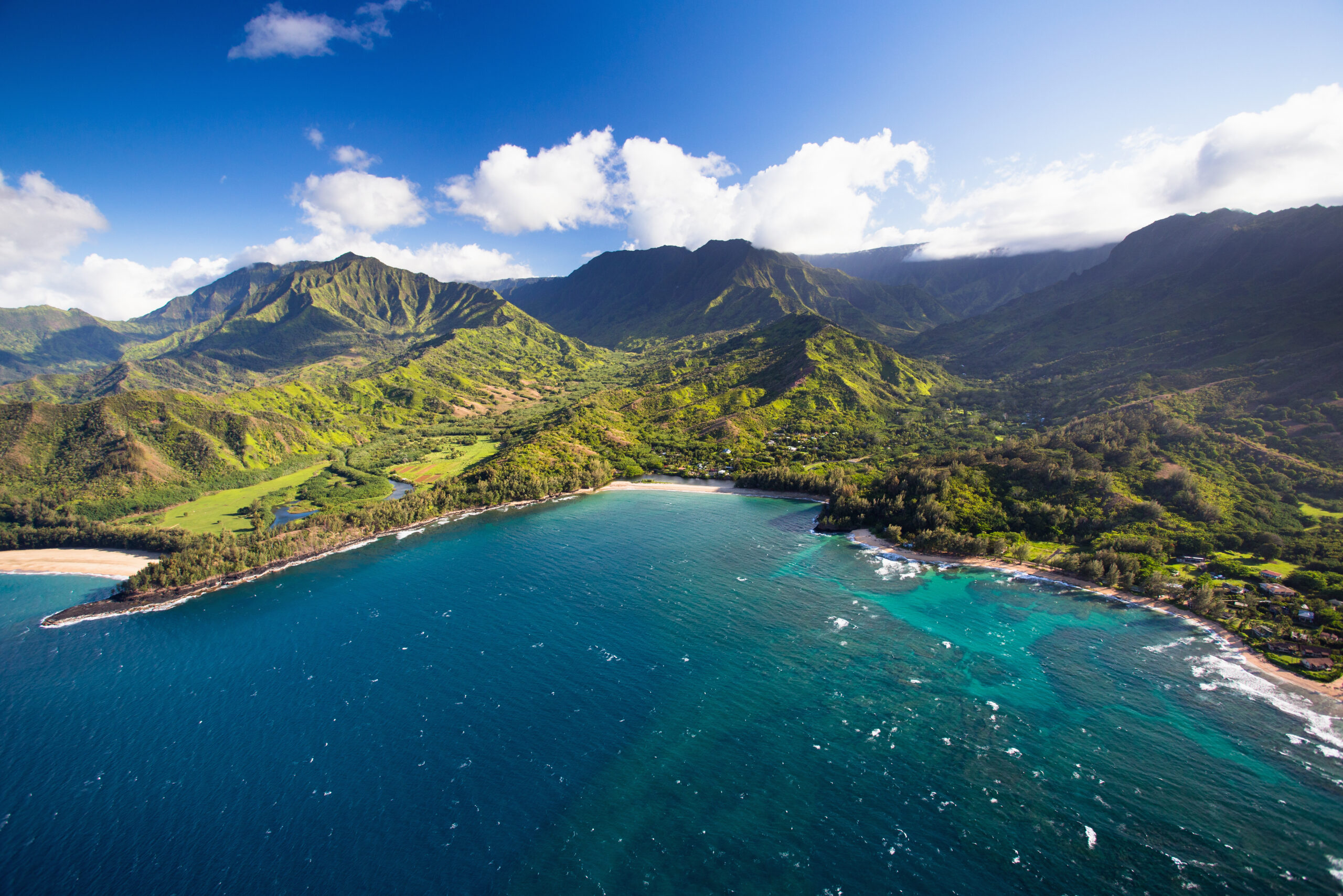 Kauai shoreline and mountainous backdrop as seen from above.