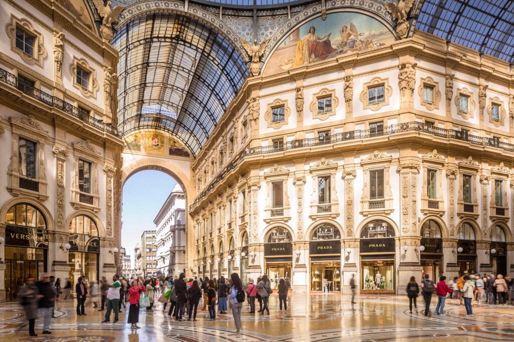 Shoppers and tourists explore the retail shops and exquisite architecture of Milan.