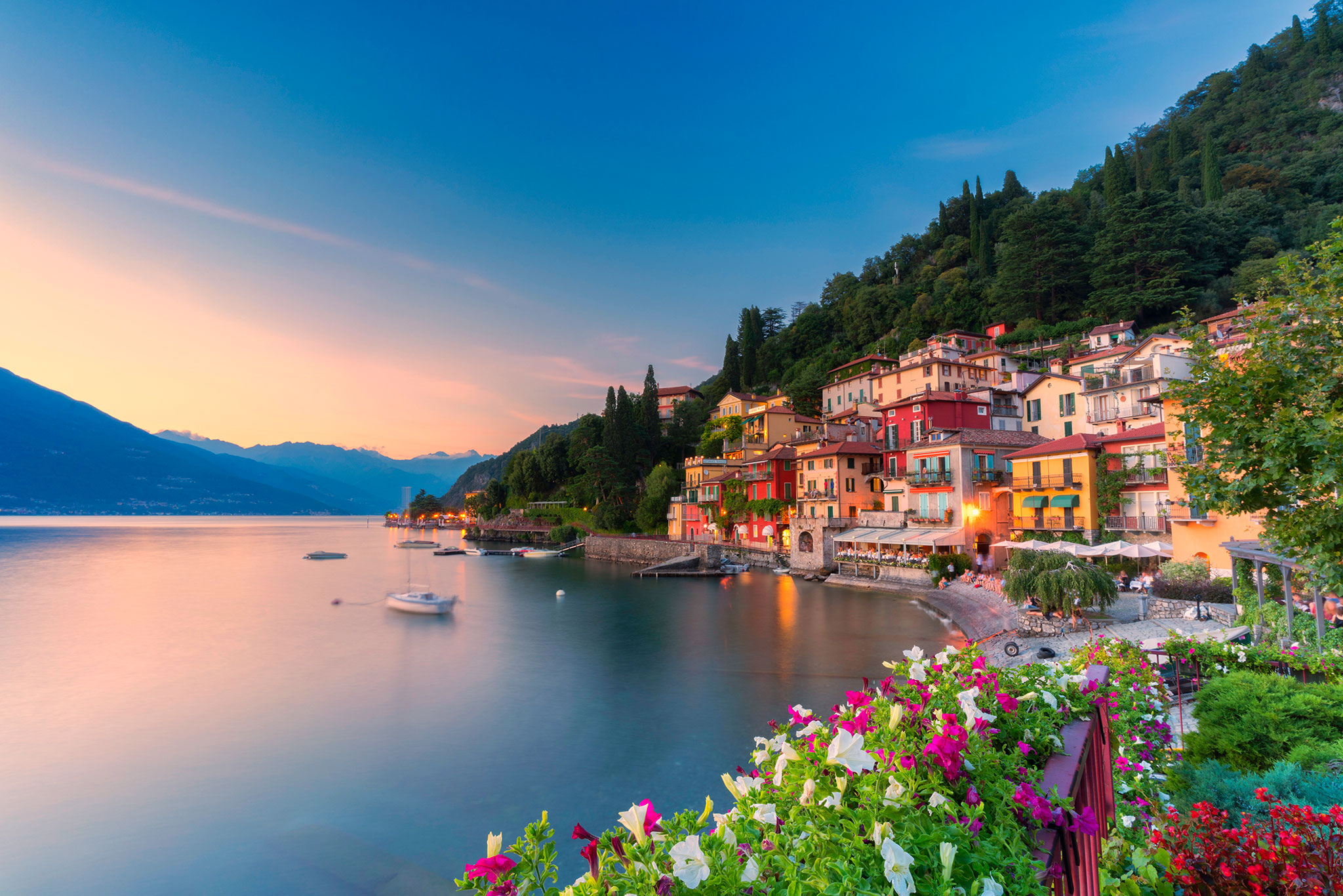 Sunset spotlights the traditional village of Varenna on the shore of Lake Como.