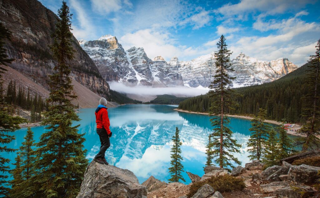 Man looking at Moraine lake at sunrise, Banff National Park, Alberta, Canada