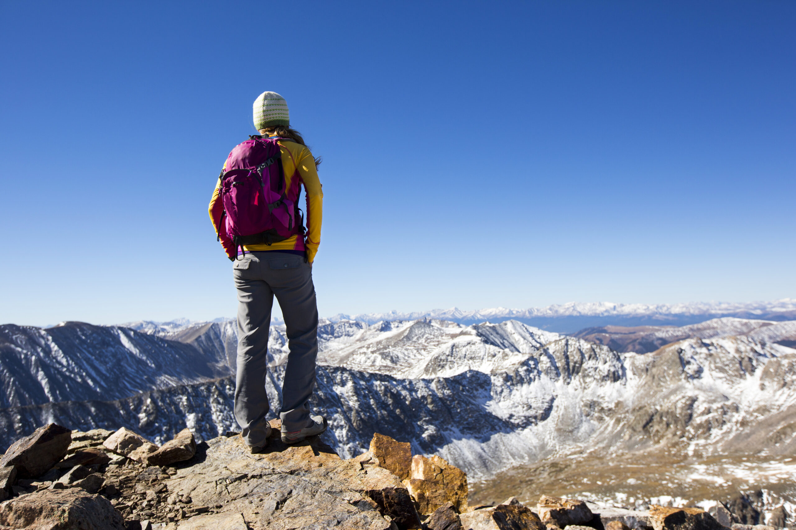 A young woman hiking on top of a 14,000 ft peak near Breckenridge, Colorado.