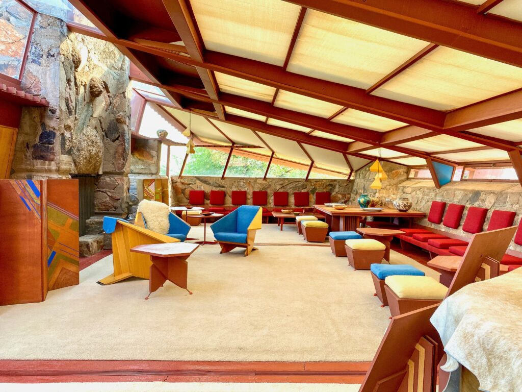 The interior of Taliesin West, Frank Lloyd Wright's winter home and architectural school in Scottsdale, Arizona, featuring unique design elements with large windows and comfortable seating areas.