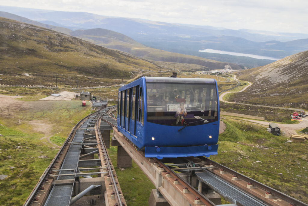 The funicular railway takes skiers and tourits to the top station at 3,600 feet, not far from the summit of Cairngorm Mountain in the Cairngorm National Park near Aviemore, Scotland. One car ascends the mountain as another descends. Cairngorm Mountain is popular with skiers in the winter and tourists and hillwalkers in the summer.