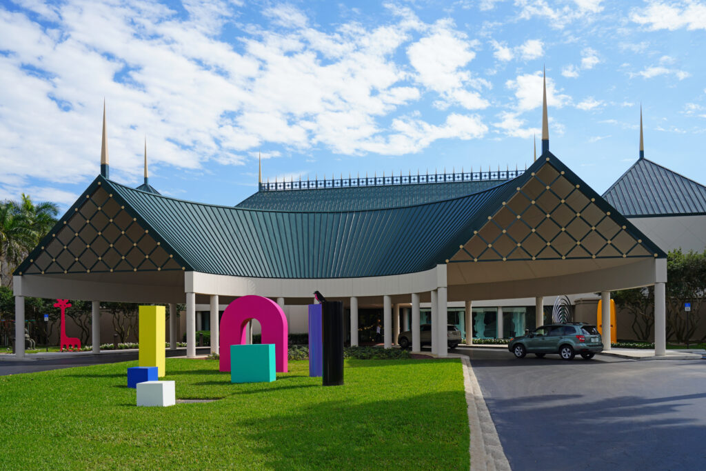 The Baker Museum with distinctive peaked architecture and colorful outdoor sculptures on a manicured lawn.